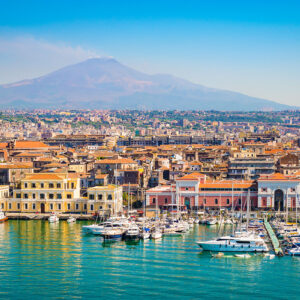 Beautiful view of Catania cruise port with smoking volcano Etna in the background.